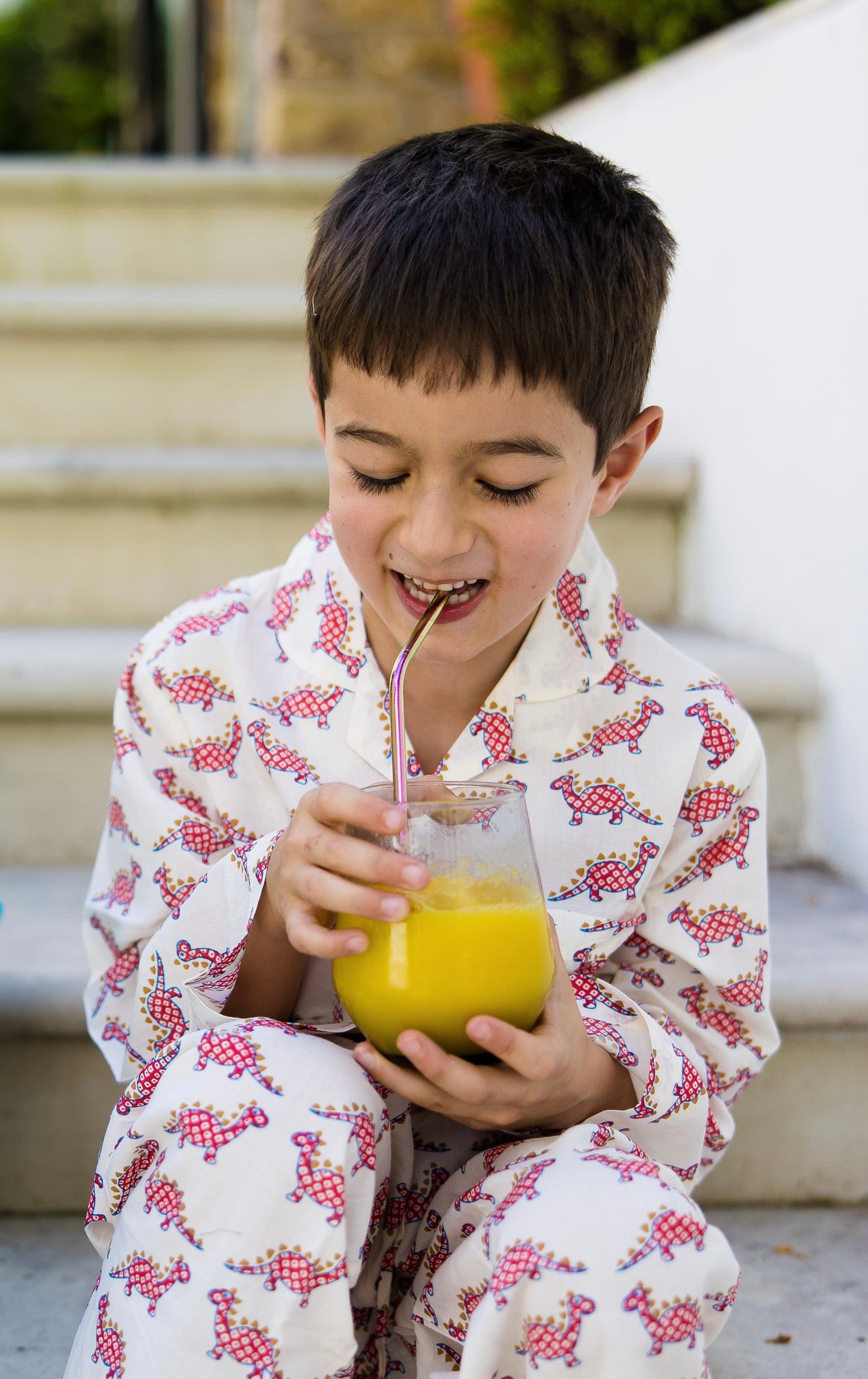 Boy wearing red dinosaur print cotton pyjamas